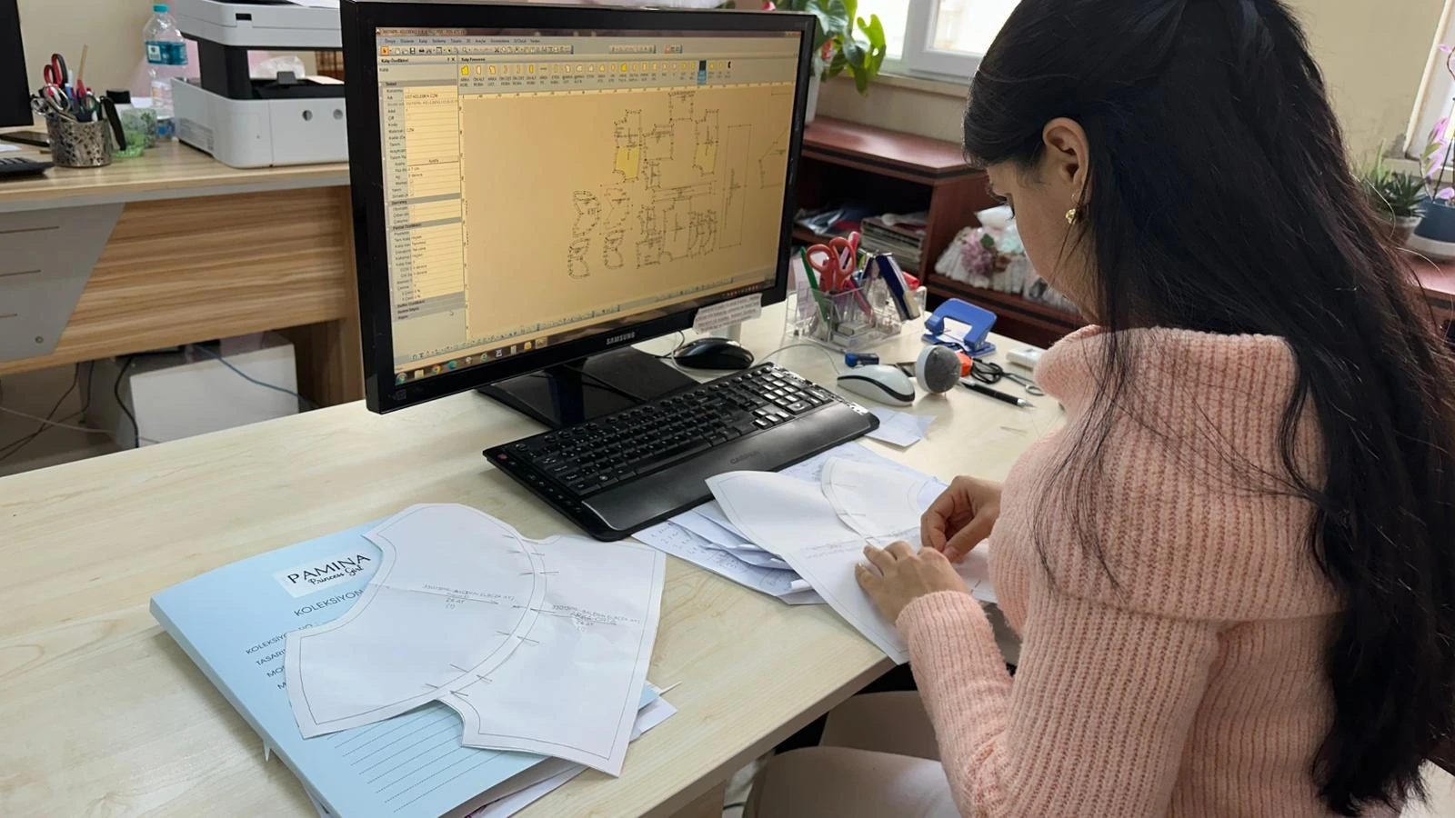Pamina team member working on garment development at a computer